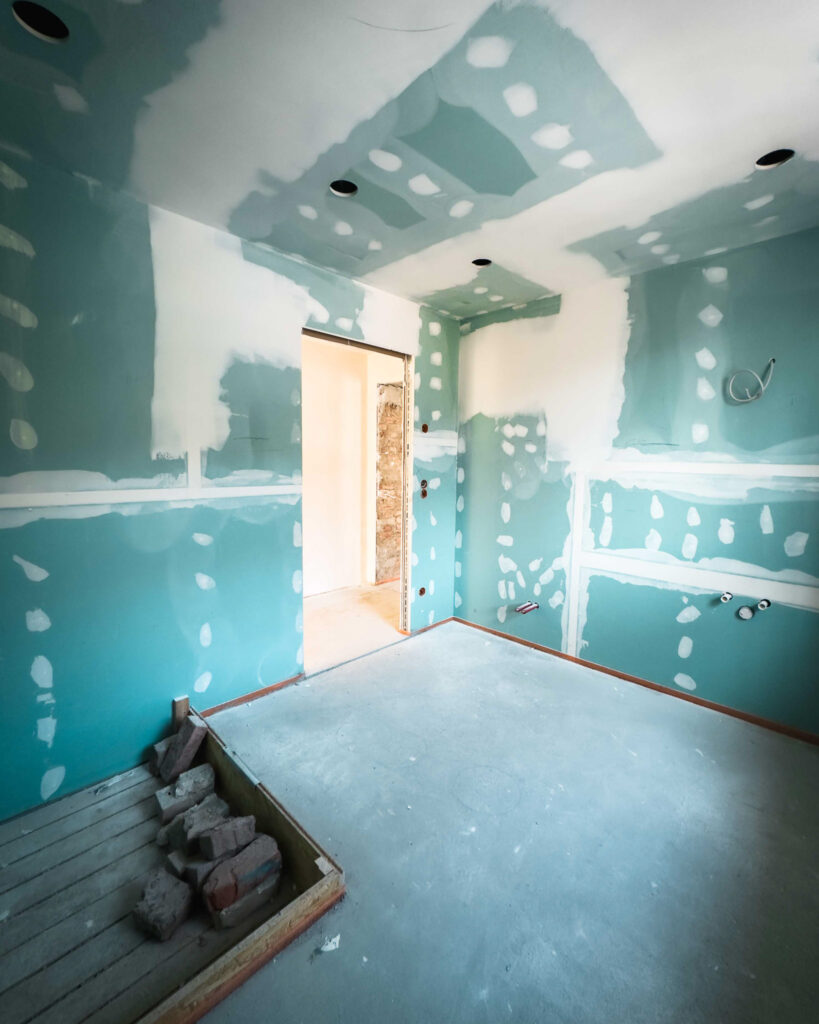 Trockenausbau eines Zimmers mit grünen Gipskartonplatten und verspachtelten Fugen.