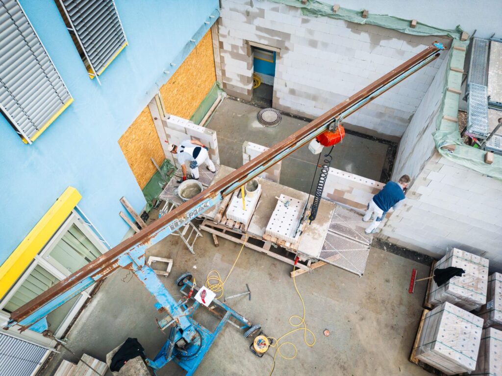 Draufsicht auf die Rohbau-Baustelle von Lindner Bau am DRK Chemnitz-Rabenstein mit Blick auf Fundamente und Mauerwerk.