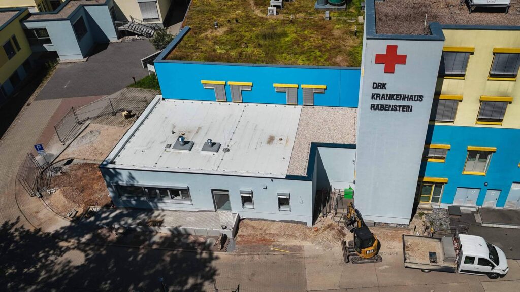 Luftaufnahme des DRK Krankenhaus Alzey mit fertiggestelltem Anbau und angrenzender Baustelle für die Außenanlagen.