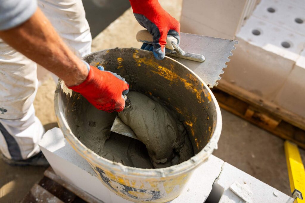 Detailaufnahme der Materialvorbereitung: Anmischen von Qualitätsmörtel für den Rohbau am DRK Rabenstein.