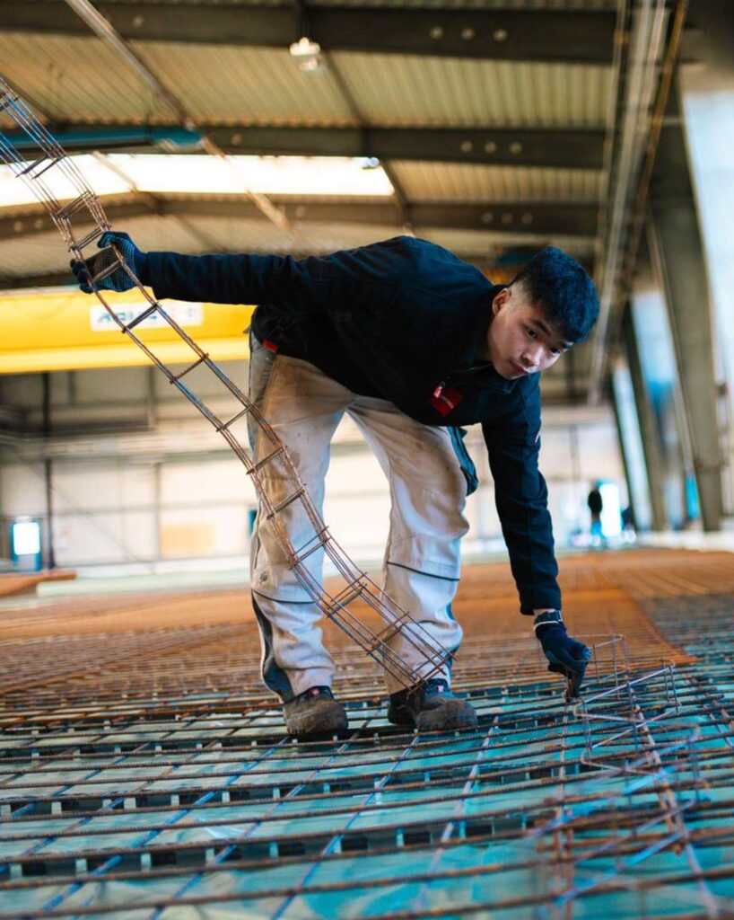 Mitarbeiter von Lindner Bau fixiert Bewehrungsstahl in der Industriehalle des Autohauses Fugel in Chemnitz.