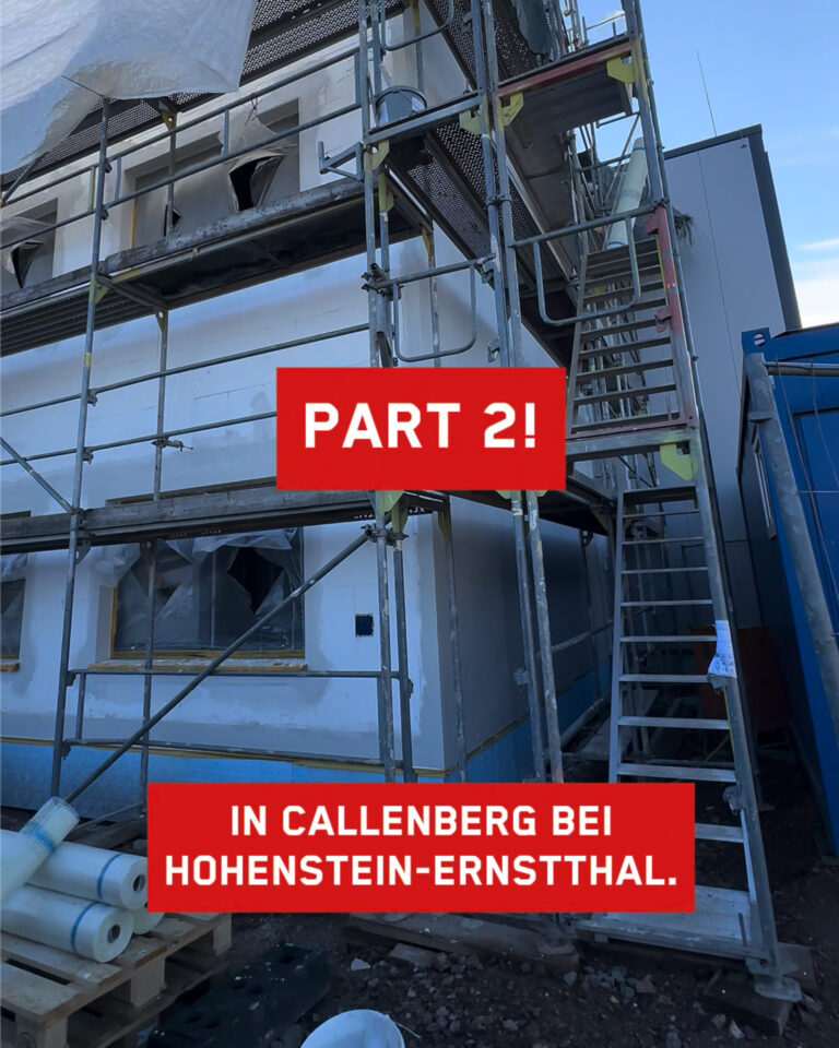 Baustelle bei der Firma Prüstel in Callenberg bei Hohenstein-Ernstthal mit Fassadengerüst, verputzter Außenwand und Baumaterialien unter blauem Himmel – Texteinblendung: Part 2.
