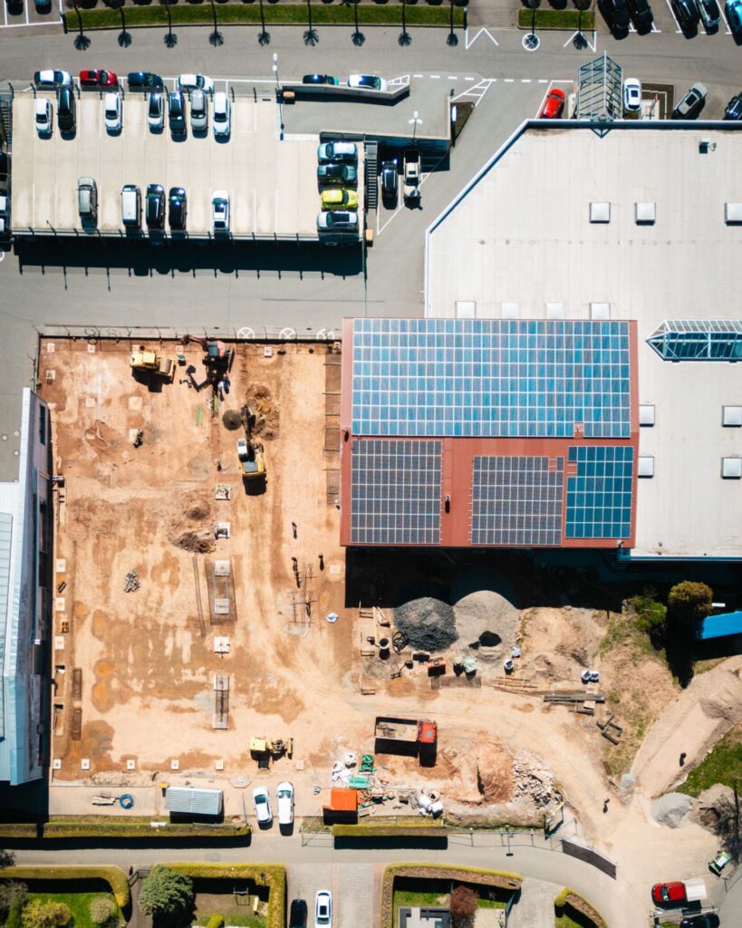 uftaufnahme einer Baustelle für ein Fugel-Autohaus mit Parkplatz und Solardachanlage.