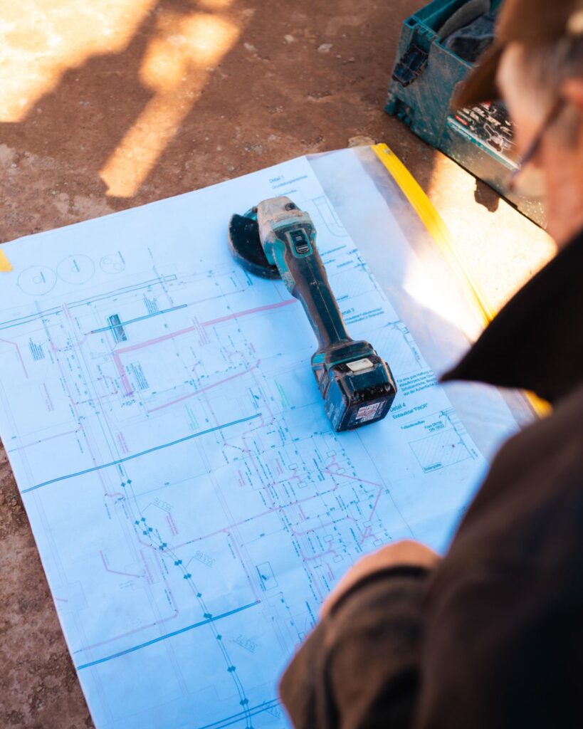 Ansicht eines Bauunternehmers oder Architekten beim Studieren von Bauplänen auf der Fugel-Baustelle.