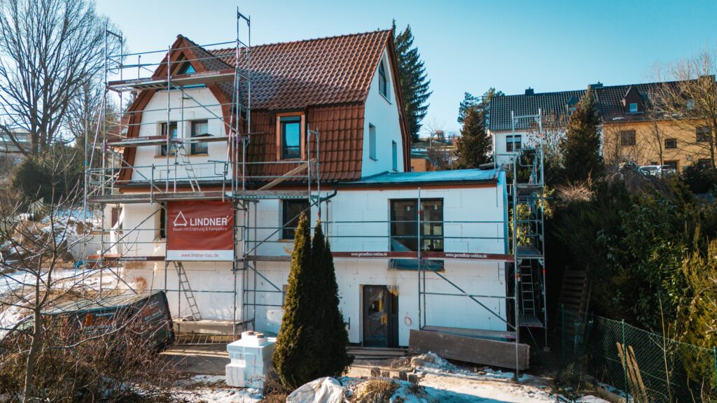 Außensansicht des zu sanierenden Hauses bei blauem Himmel und Sonnenschein