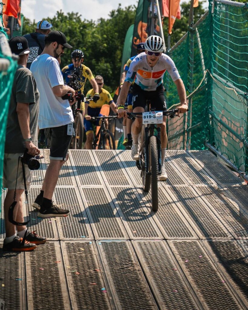 Ein MTB-Fahrer von Team Fritzsche überquert eine Brücke auf dem Rundkurs des Heavy24 Rennens in Chemnitz