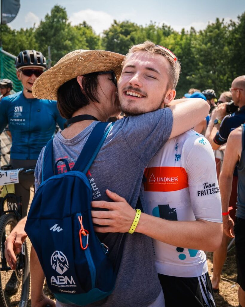 Glücklicher Radrennsportler von Team Fritzsche wird nach dem 24-Stunden-MTB-Rennen herzlich umarmt