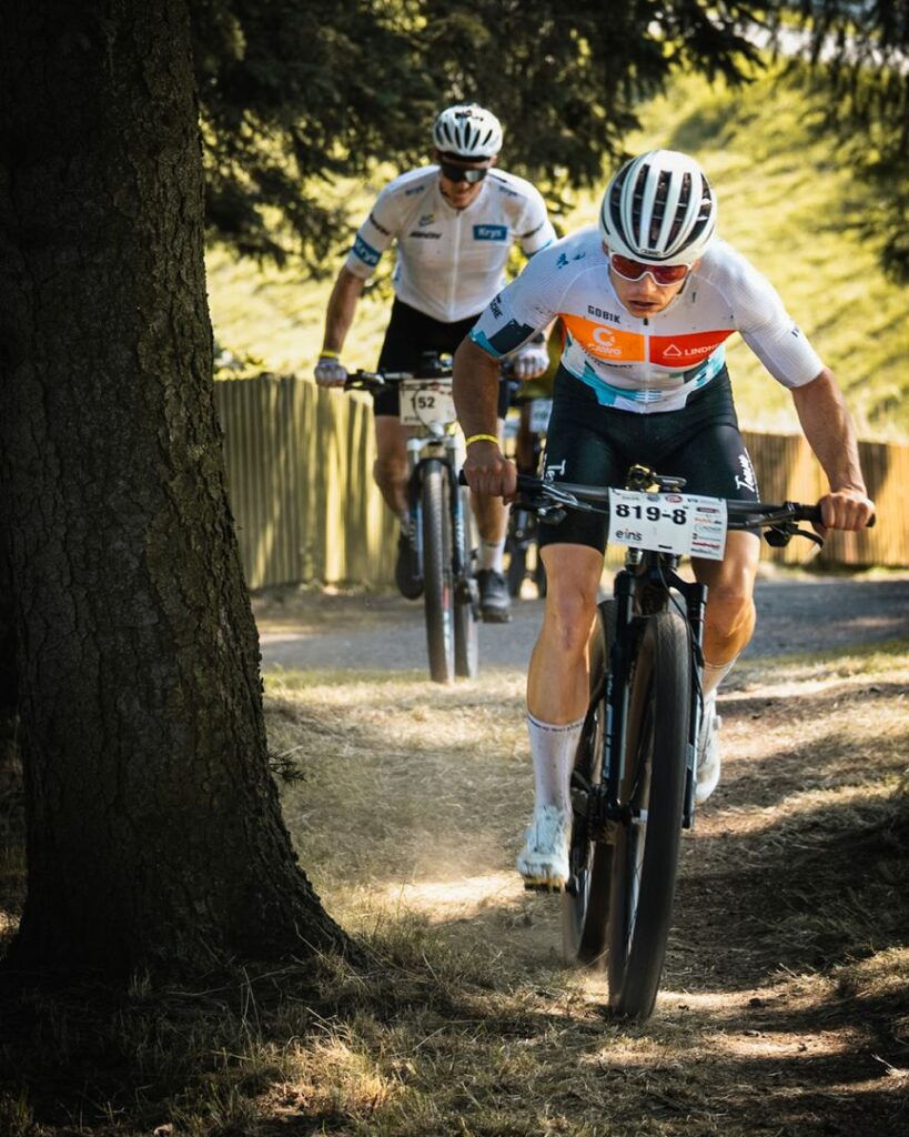 Ein Mountainbike-Fahrer vom Team Fritzsche in Aktion auf einem Waldweg beim Heavy24 Radrennen