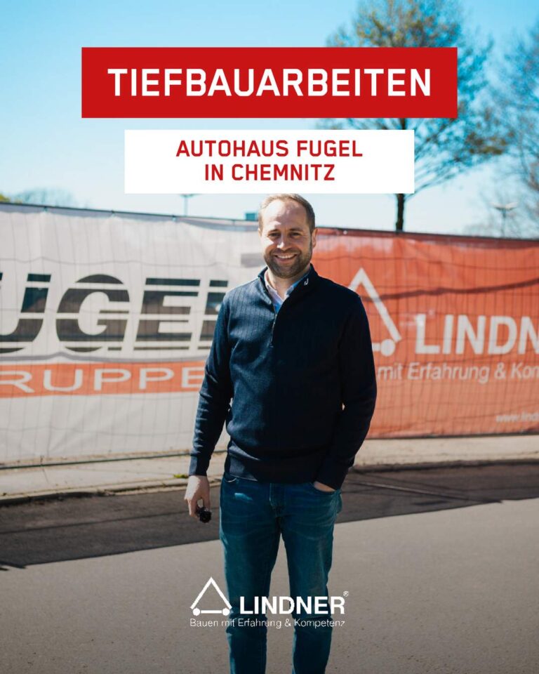 Tony Lindner steht lächelnd vor zwei Bauzaunbannern des AAutohauses Fugel und Lindner Bau. Text: "Tiefbauarbeiten Autohaus Fugel"