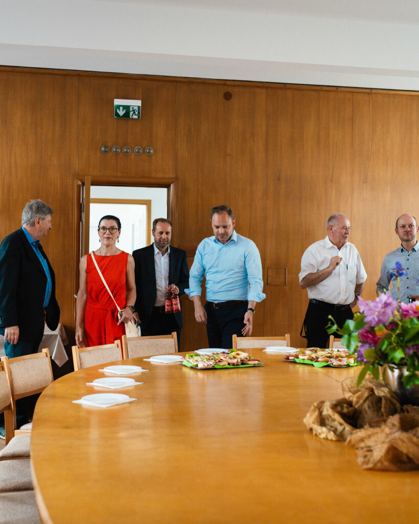 Die Delegation betritt den Besprechungsraum: Ina Klemm, Tony Lindner, Alexander Dierks, Lars Kluge und weitere Beteiligte kommen gut gelaunt durch eine Holztür in den Raum mit dem großen, für den Austausch vorbereiteten Tisch.