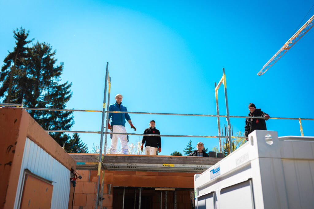 Bauhandwerker auf dem Gerüst bei strahlendem Sonnenschein auf einer Baustelle in Chemnitz-Adelsberg