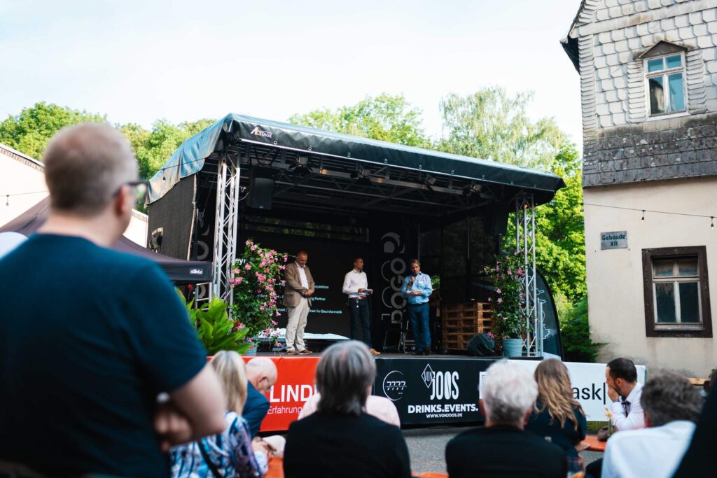 Blick aus Publikumspersektive auf die Bühne während einer Präsentation.