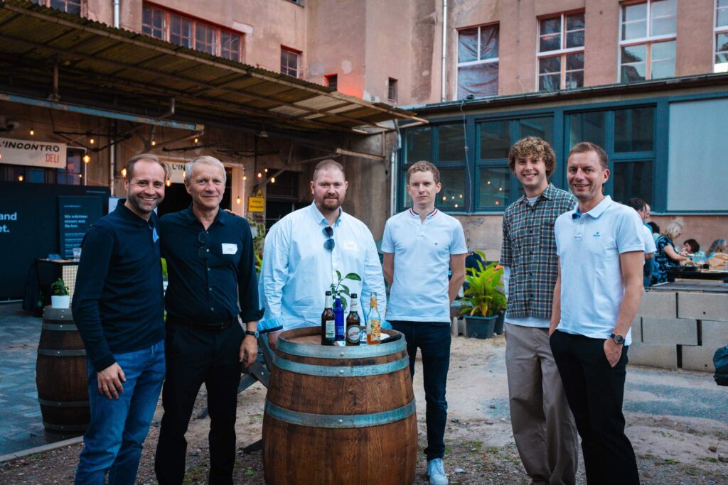 Sechs Netzwerk-Partner und Organisatoren posieren im Innenhof des ROGO Future Campus.