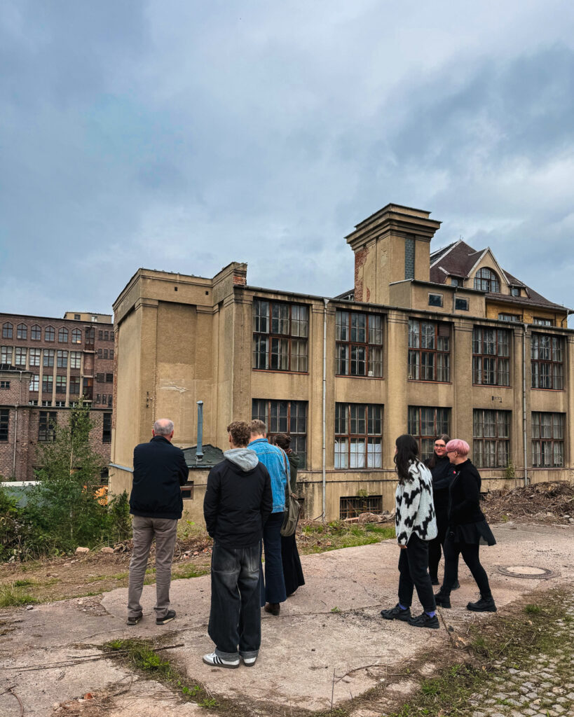 Besucher betrachten die alte Industriearchitektur und die historischen Gebäude des ROGO-Werks