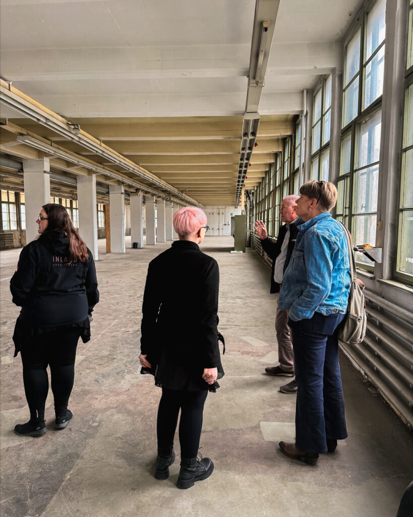 rchitektur-Interessierte in einer großen, lichtdurchfluteten Industriehalle des ROGO-Werks